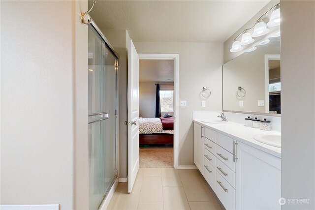 bathroom with tile patterned flooring, vanity, and a shower with door