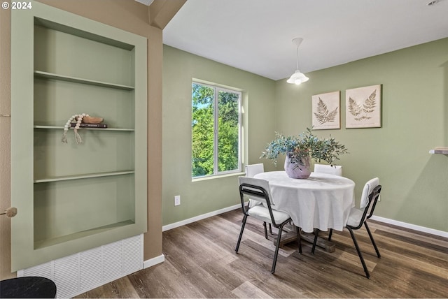 dining area featuring built in shelves and hardwood / wood-style flooring