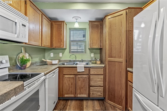 kitchen with white appliances, sink, and dark wood-type flooring