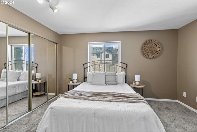 carpeted bedroom with a closet and multiple windows