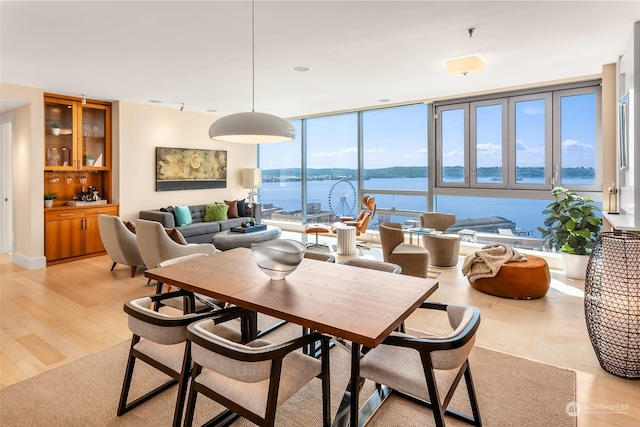 dining area featuring a water view and light hardwood / wood-style floors