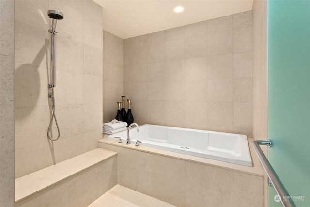 bathroom with tile walls and independent shower and bath