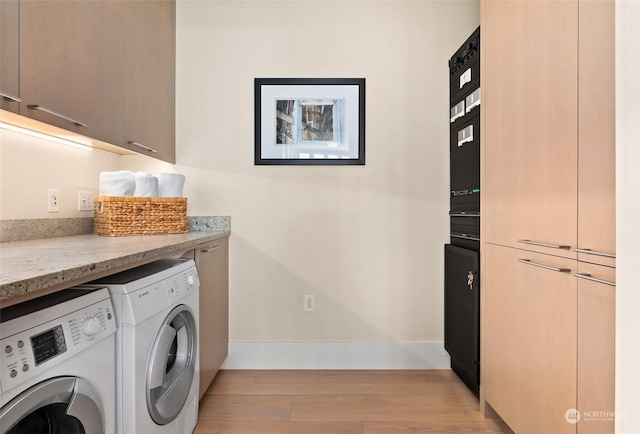 laundry area featuring light hardwood / wood-style floors, cabinets, and separate washer and dryer