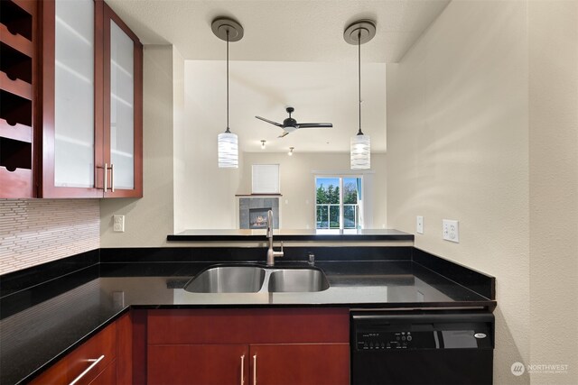 kitchen with ceiling fan, sink, decorative light fixtures, dishwasher, and a tiled fireplace