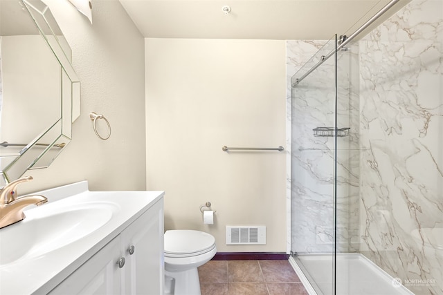 bathroom with tile patterned flooring, vanity, toilet, and tiled shower