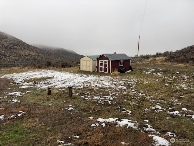 view of yard with a mountain view and a shed