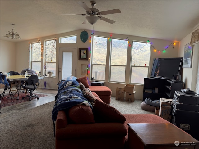 living room with hardwood / wood-style floors, ceiling fan with notable chandelier, and lofted ceiling