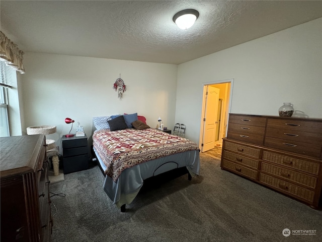 bedroom with dark colored carpet and a textured ceiling