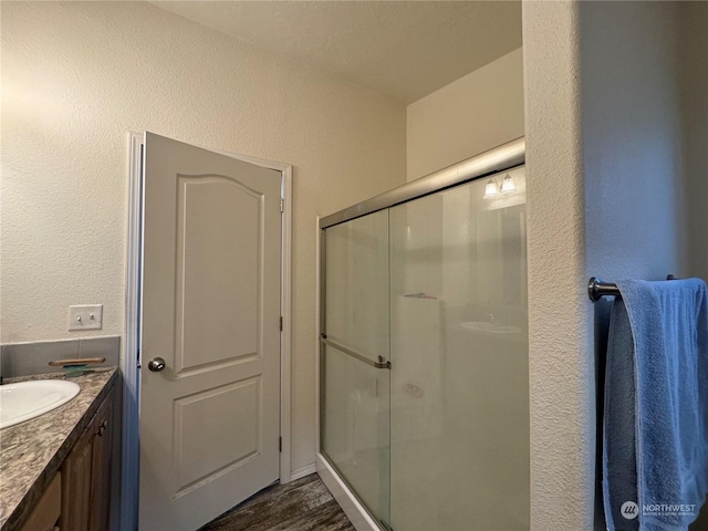 284 Blue Lake Rd, Oroville, WA 98844 - bathroom with a textured wall, a shower stall, vanity, and wood finished floors