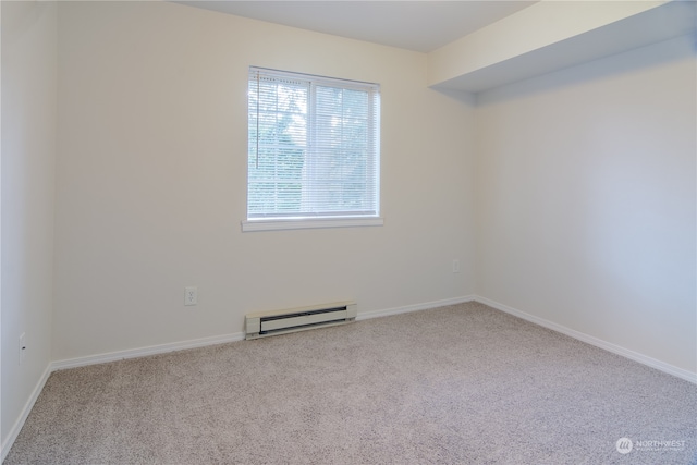 spare room featuring light colored carpet and baseboard heating