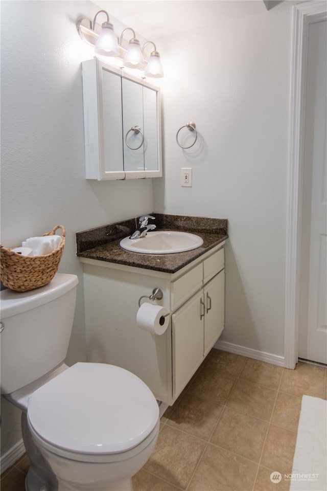 bathroom featuring tile patterned floors, vanity, and toilet