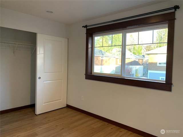 unfurnished bedroom with light hardwood / wood-style floors and a closet