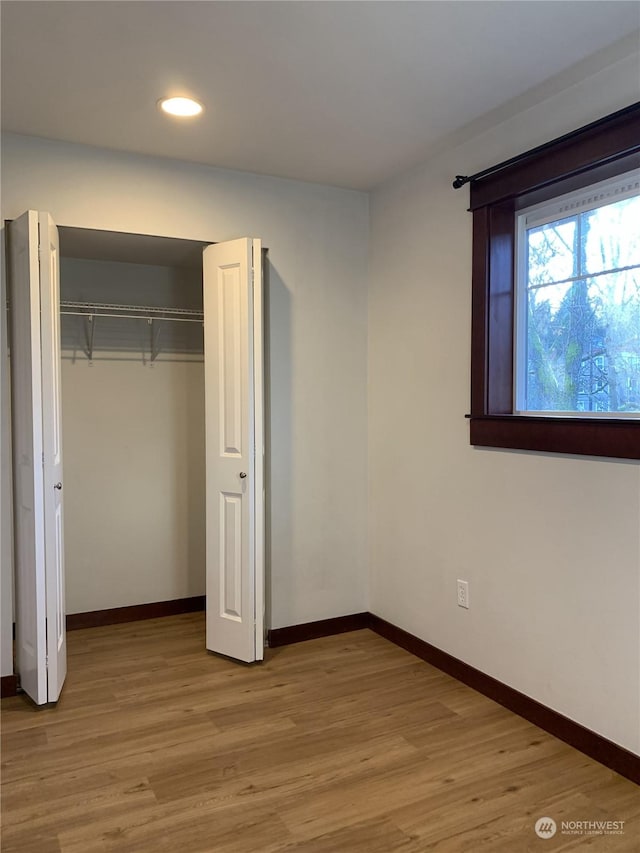 unfurnished bedroom featuring a closet and light hardwood / wood-style floors