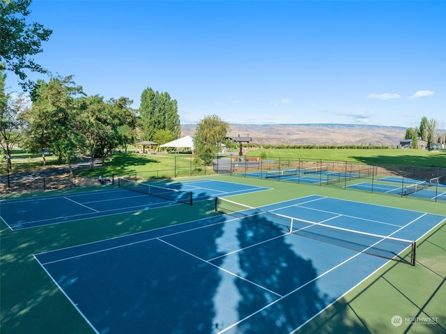 view of tennis court with a mountain view and basketball hoop