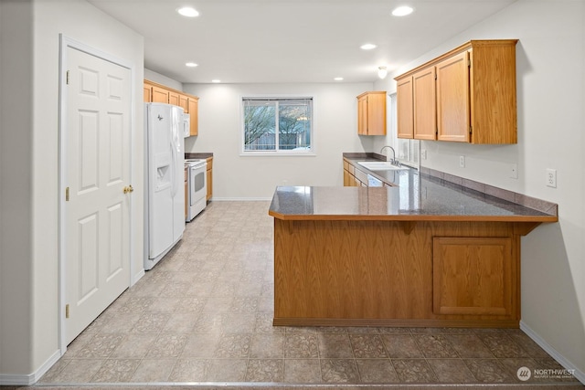 kitchen with kitchen peninsula, sink, and white appliances