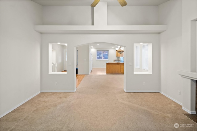 unfurnished living room featuring ceiling fan and carpet floors