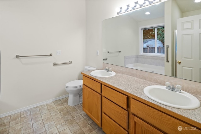 bathroom featuring a washtub, vanity, and toilet