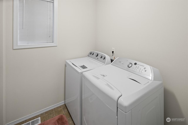 washroom with washing machine and dryer and dark tile patterned flooring