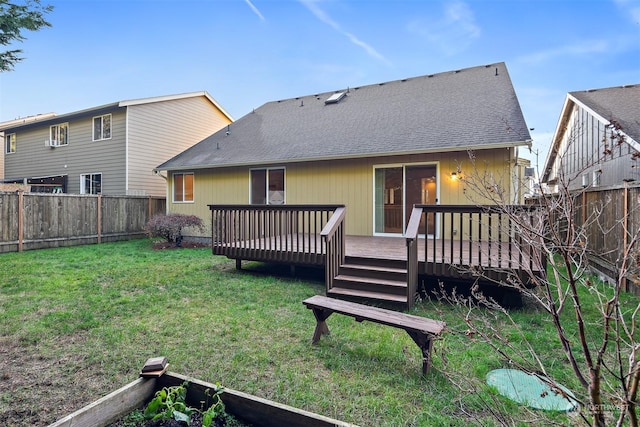 rear view of property featuring a yard and a deck