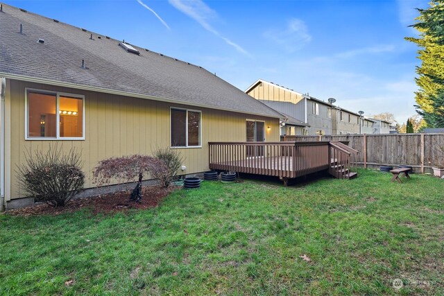 rear view of property with a lawn and a wooden deck