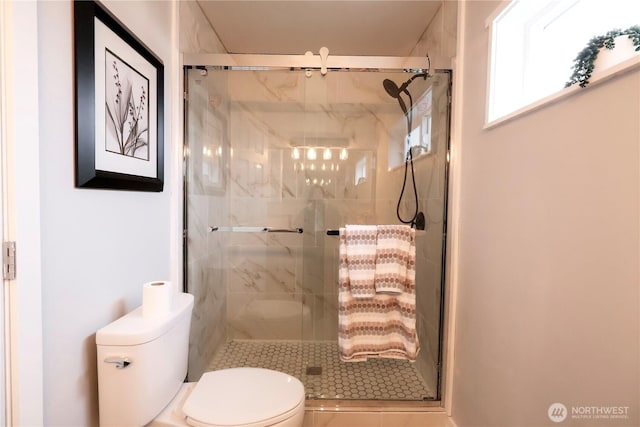 bathroom with a shower stall and toilet