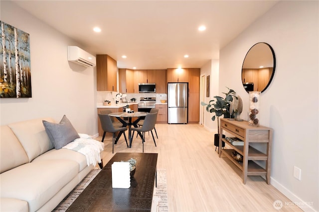 living room with recessed lighting, light wood-style flooring, baseboards, and a wall mounted AC