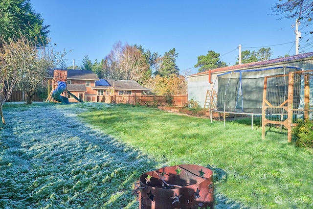 view of yard featuring a playground and a trampoline