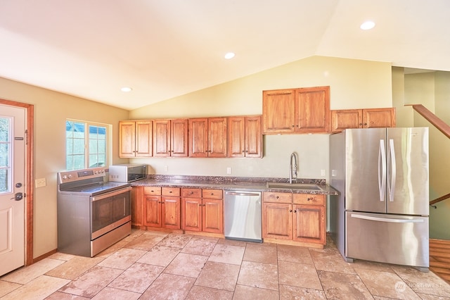 kitchen featuring appliances with stainless steel finishes, lofted ceiling, and sink