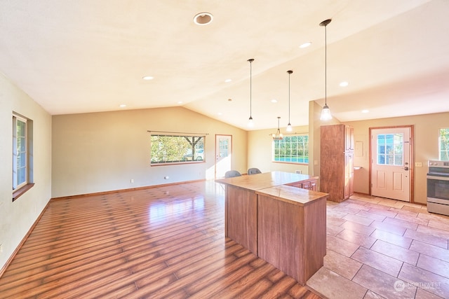 kitchen with pendant lighting, light hardwood / wood-style floors, a wealth of natural light, and stainless steel stove