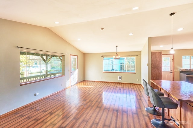 interior space with hardwood / wood-style flooring, vaulted ceiling, and a healthy amount of sunlight