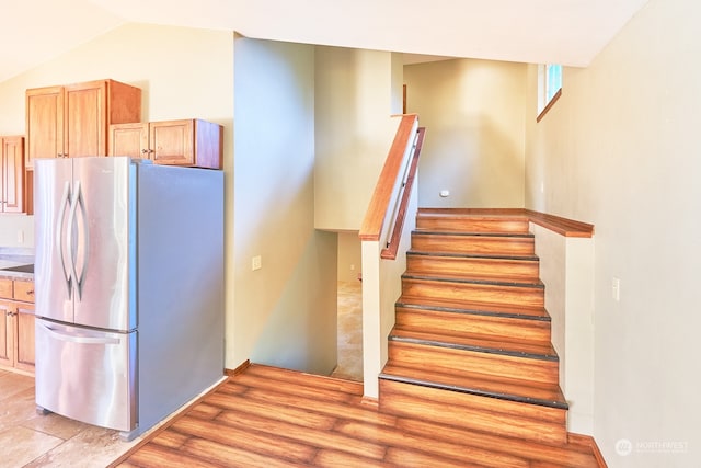 stairway featuring lofted ceiling and hardwood / wood-style flooring