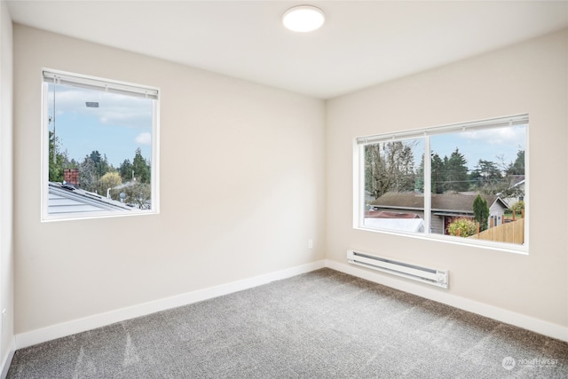 spare room with carpet, a baseboard radiator, and a wealth of natural light