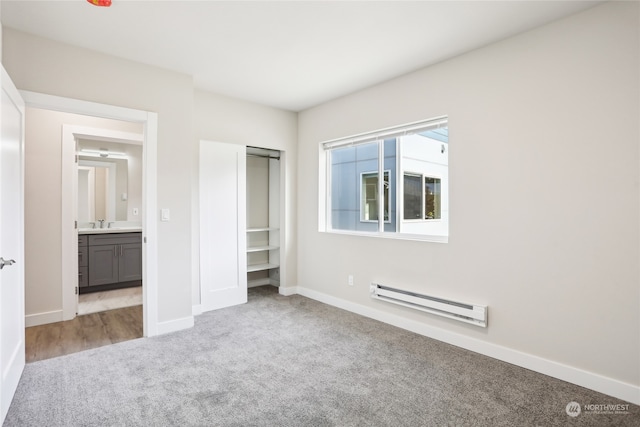 unfurnished bedroom featuring baseboard heating and light colored carpet