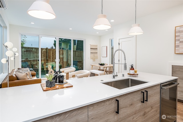 kitchen featuring pendant lighting, hardwood / wood-style flooring, and sink