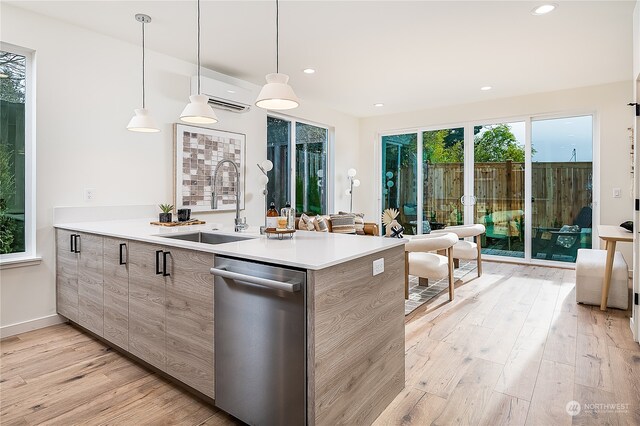 kitchen featuring hanging light fixtures, light wood-type flooring, a wealth of natural light, and sink