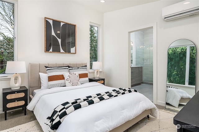 bedroom featuring ensuite bathroom and a wall mounted AC