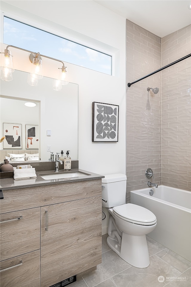 full bathroom featuring vanity, tiled shower / bath combo, tile patterned floors, and toilet