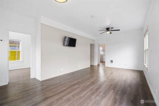 unfurnished living room featuring ceiling fan and dark wood-type flooring