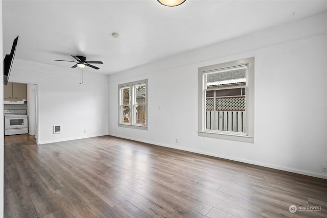 unfurnished living room featuring dark hardwood / wood-style floors, a wealth of natural light, and ceiling fan