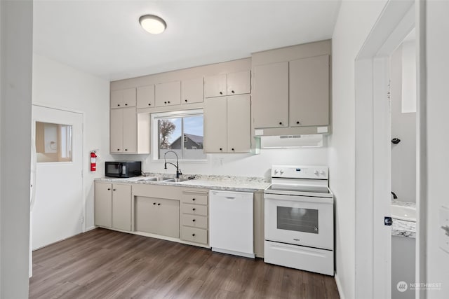 kitchen featuring dark hardwood / wood-style flooring, white appliances, cream cabinets, and sink