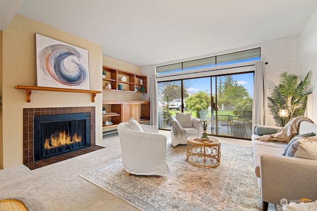 carpeted living room featuring a tiled fireplace