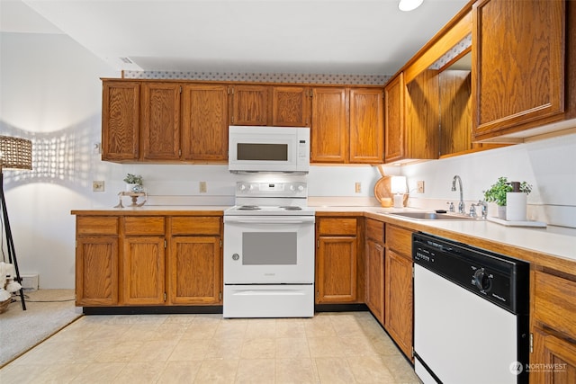 kitchen featuring white appliances and sink