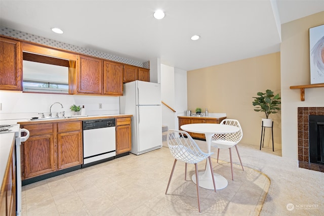 kitchen featuring a fireplace, white appliances, and sink