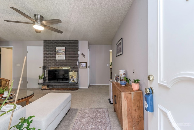 carpeted living room with ceiling fan, a fireplace, and a textured ceiling