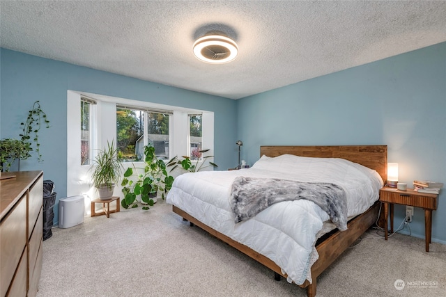 bedroom featuring light colored carpet and a textured ceiling