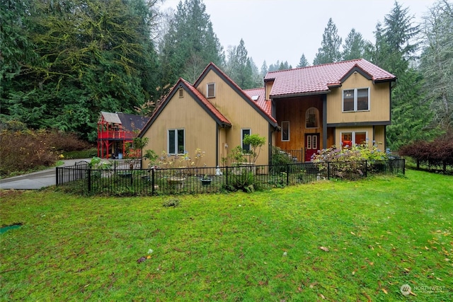 rear view of property featuring a lawn