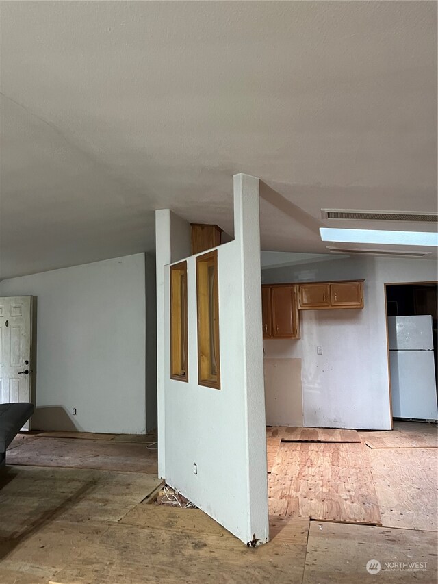 kitchen featuring white refrigerator and vaulted ceiling