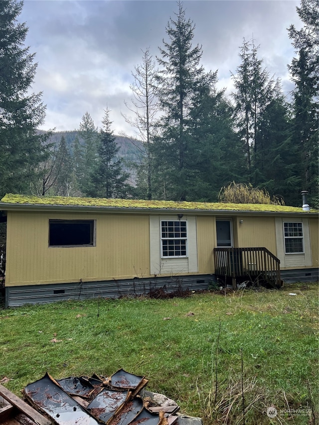 exterior space with a front yard and a wooden deck