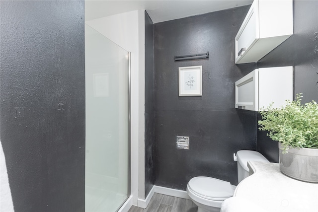 bathroom featuring hardwood / wood-style flooring, toilet, and walk in shower