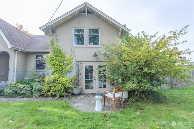 back of house featuring a yard and french doors